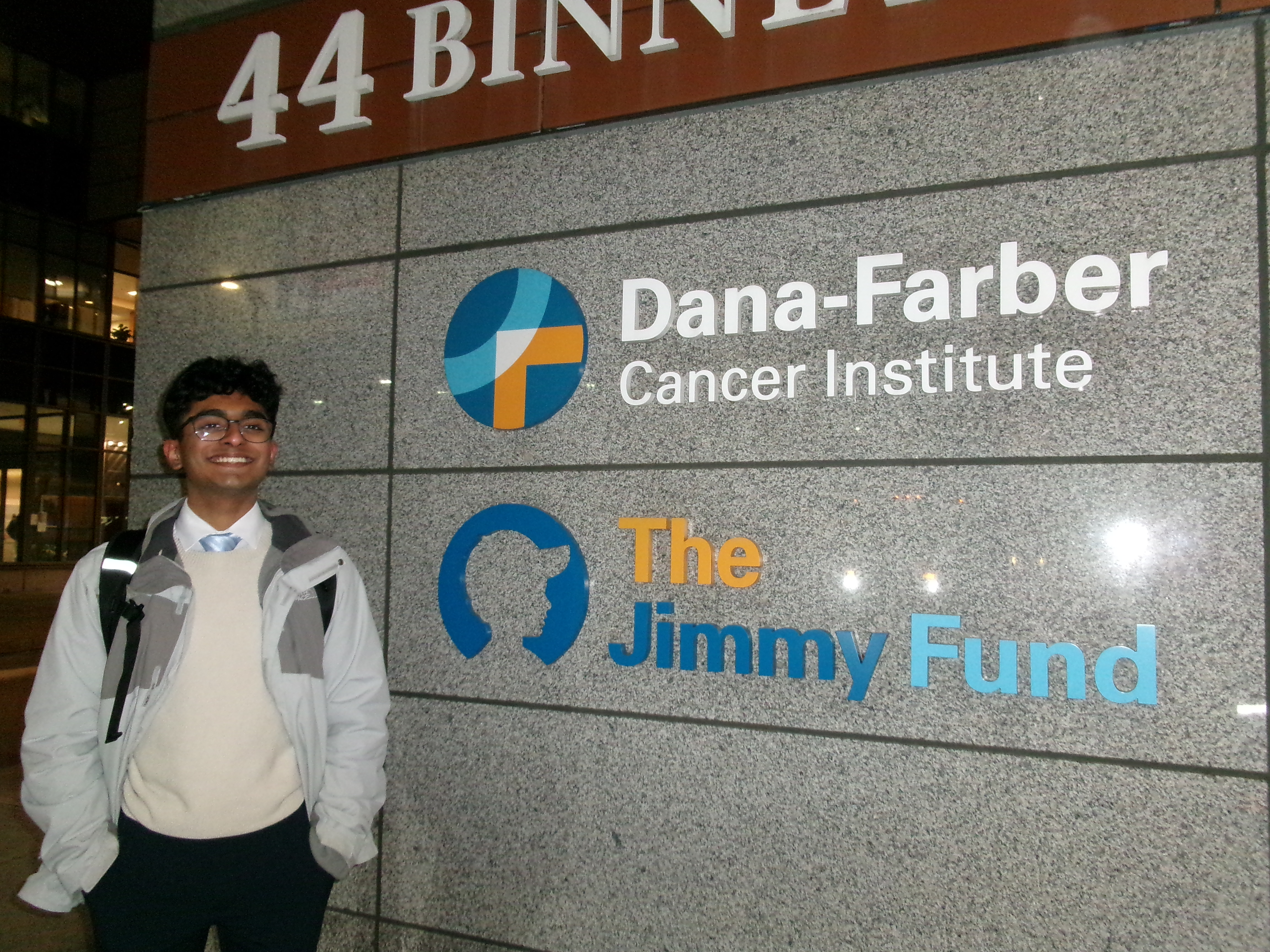 Vishnu stands by a sign for Dana-Farber Research Institute.