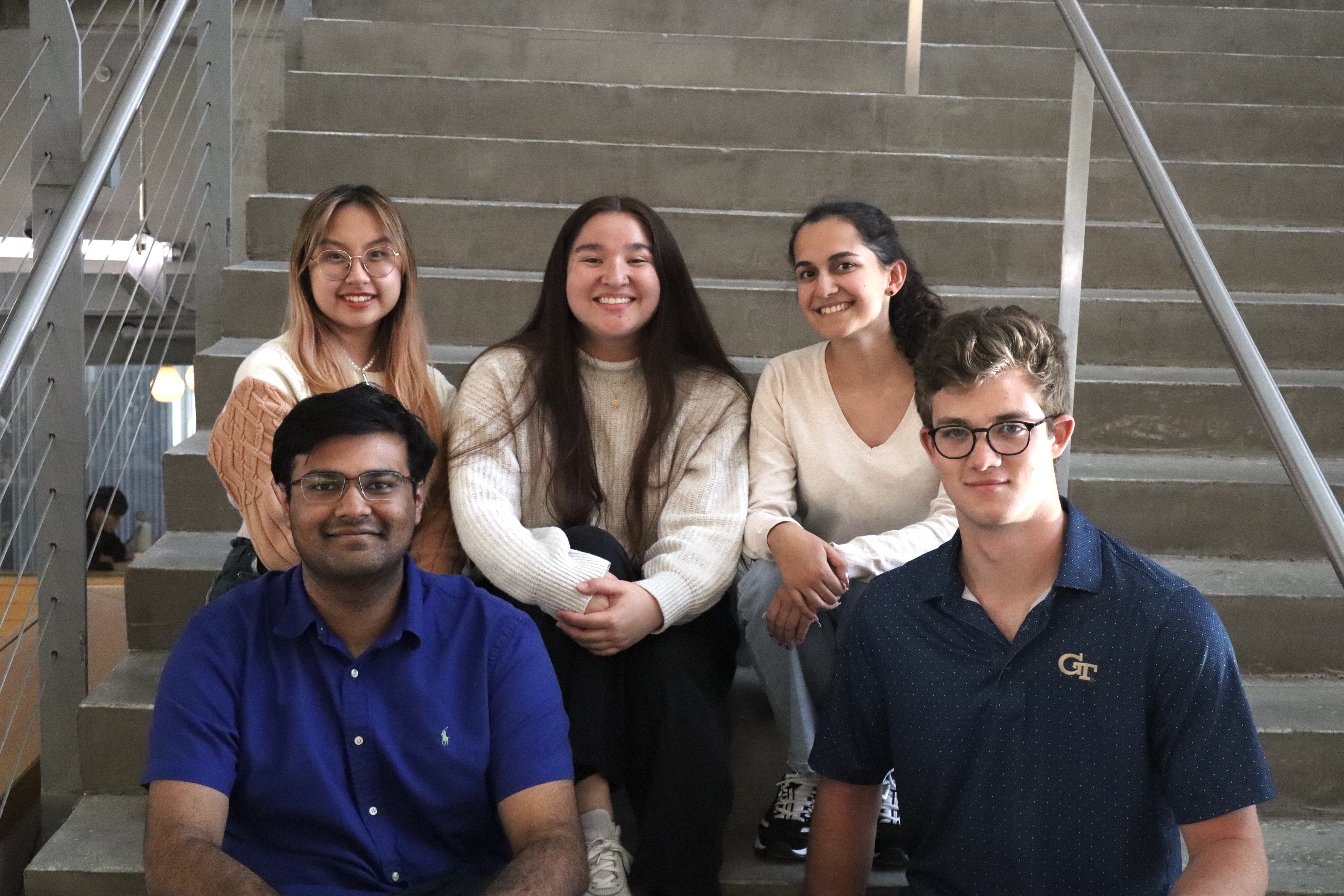 Jocelyn Le, Brooke Chambliss, Mariah Castillo, Arnav Hiray, and Harry Watkins sit on the steps in Clough and smile at the camera.