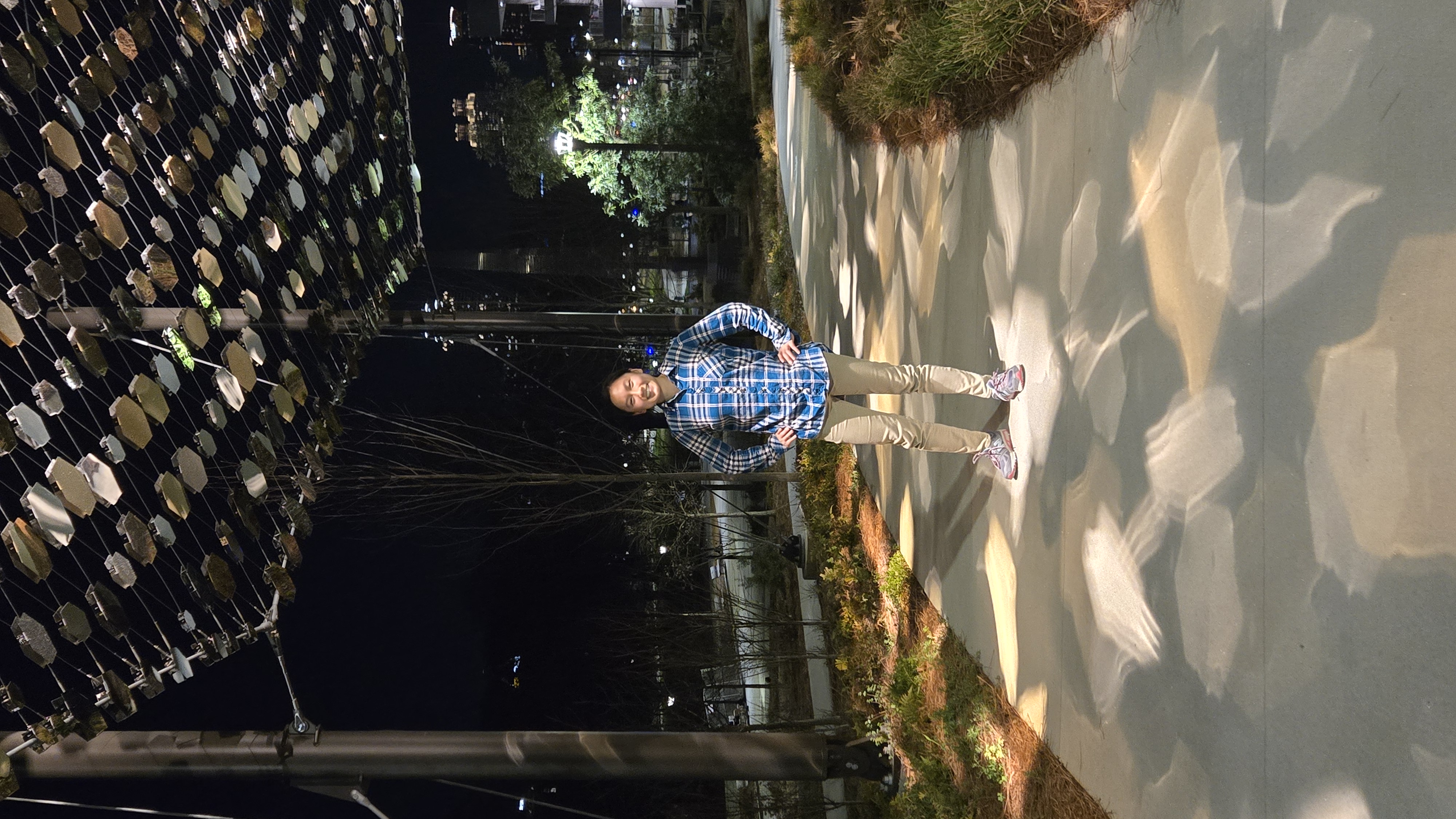 Susanna stands under the Women's Walk by the Student Center at night.