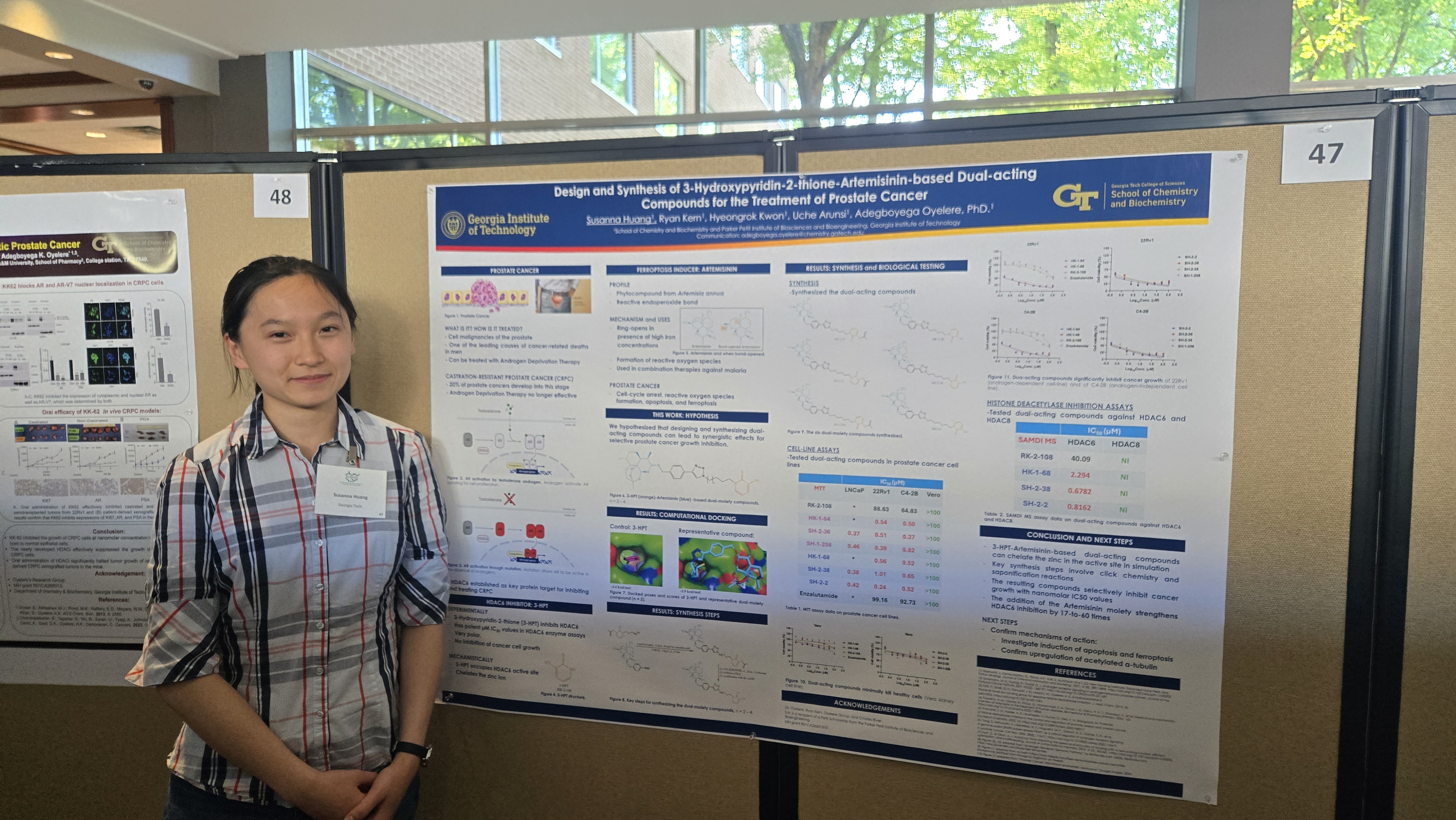 Susanna stands next to a poster about her work.