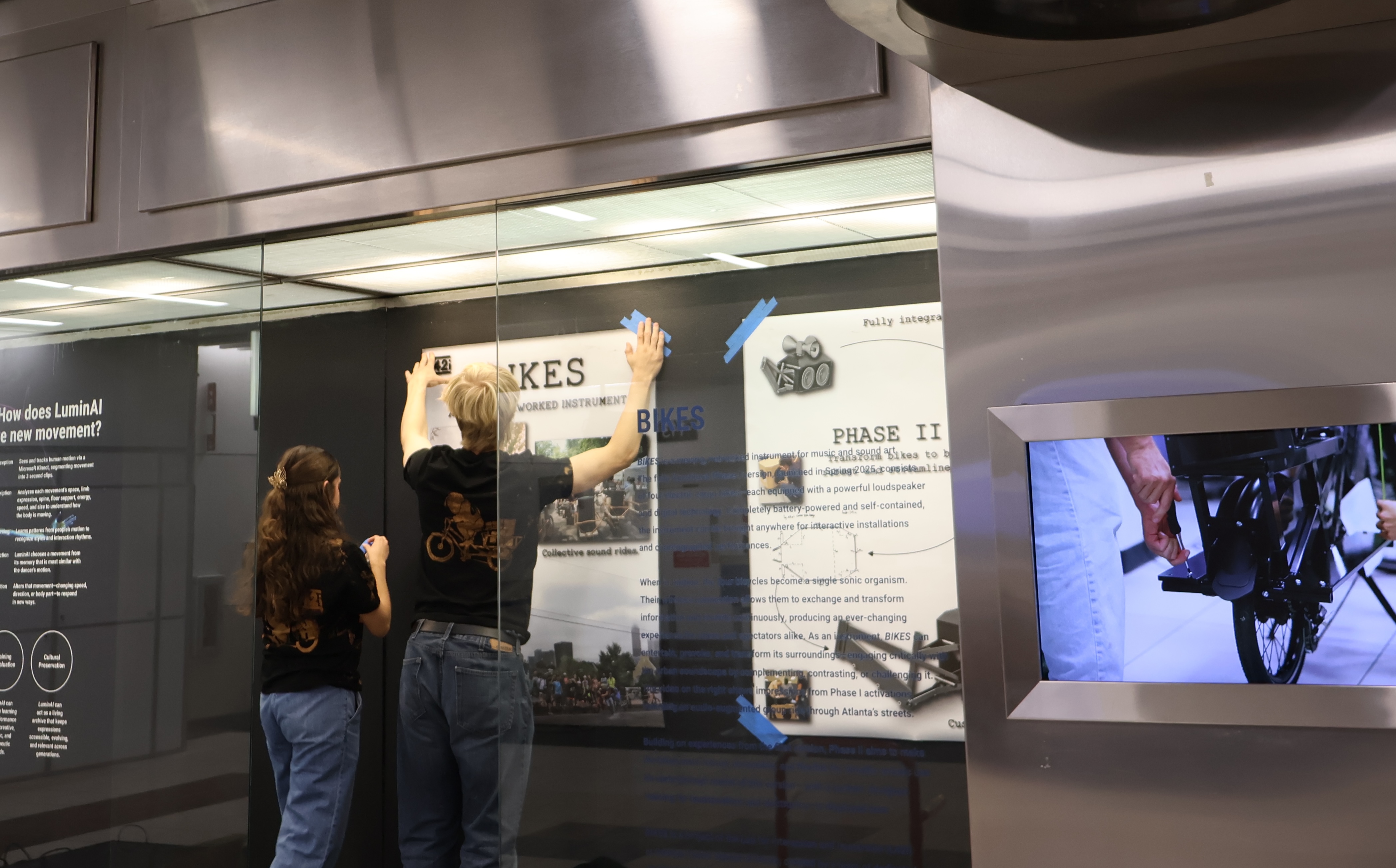 Laura hangs an exhibit in the ATL airport.