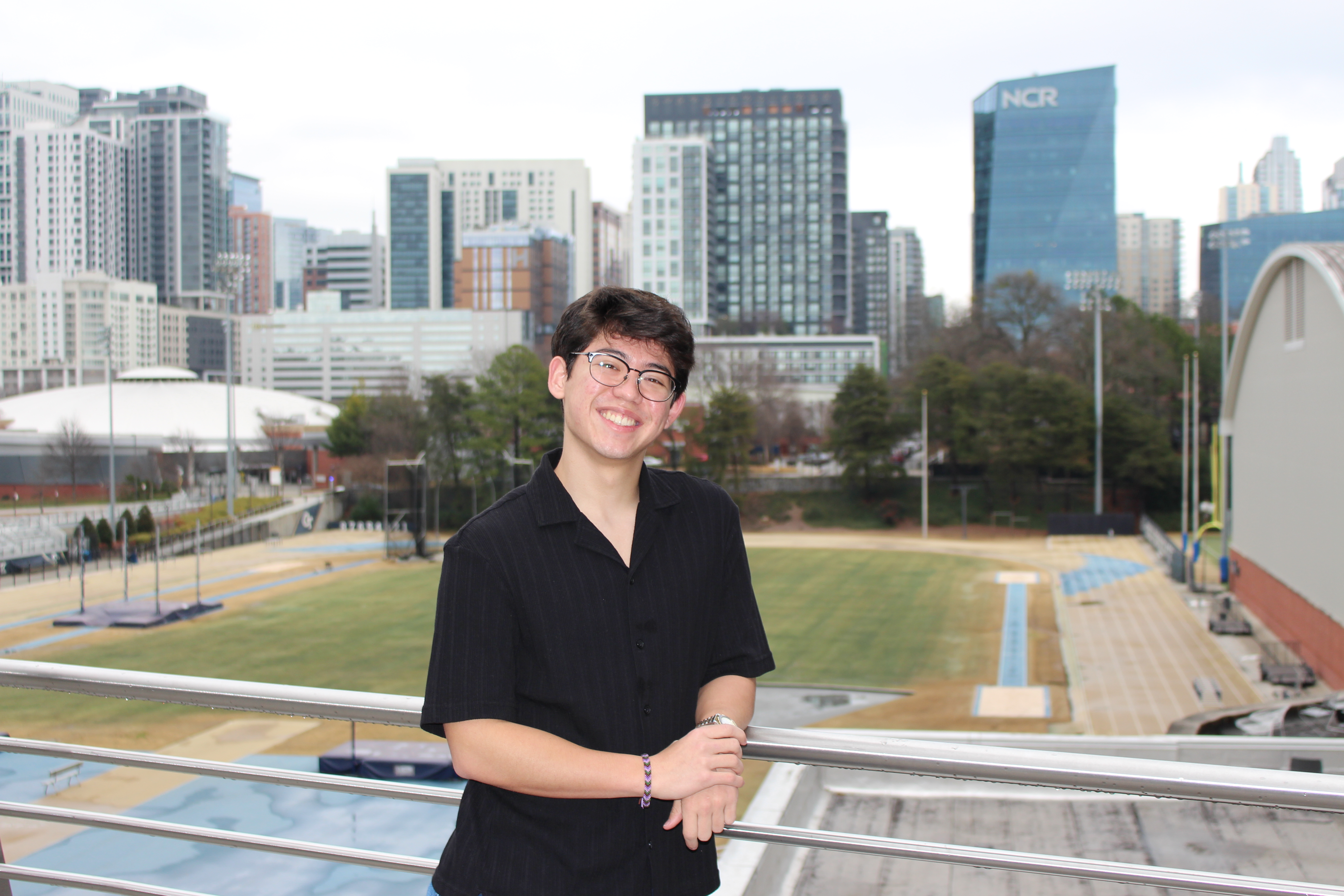 Seth smiles at the camera with Tech's Athletic facilities in the background.