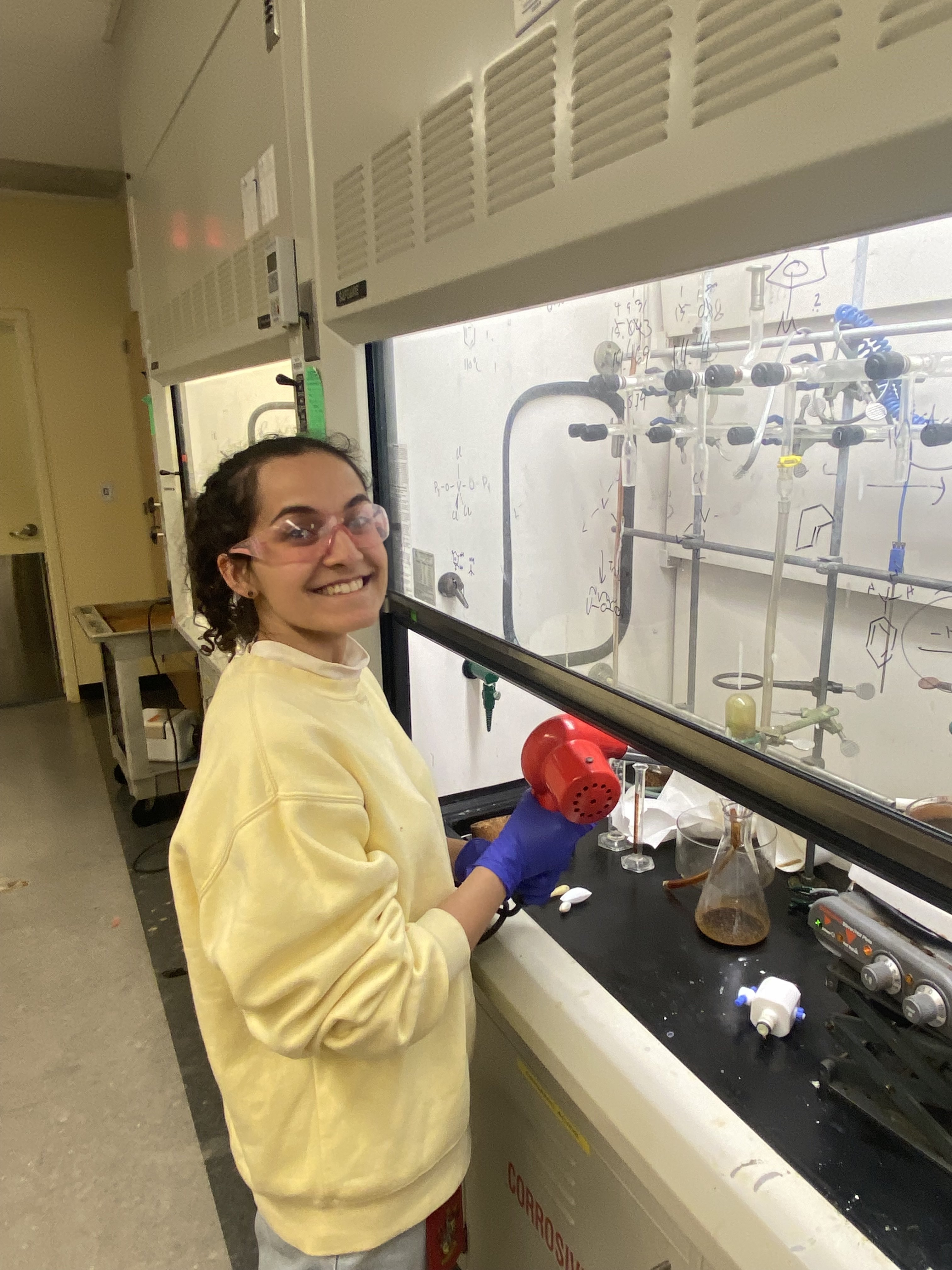 Mariah works in the lab and smiles at the camera.