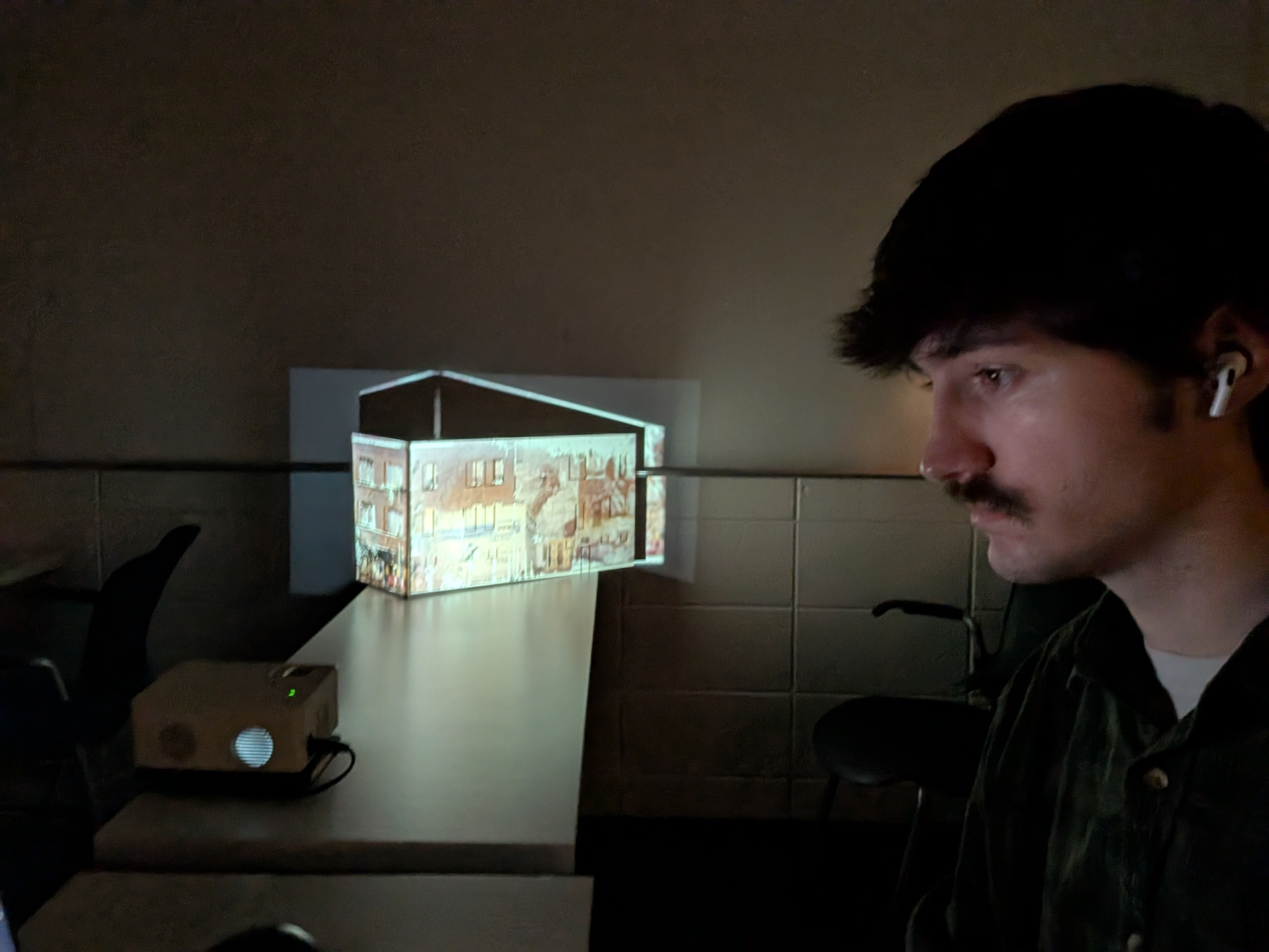 Brian watches a glowing replica of a building.