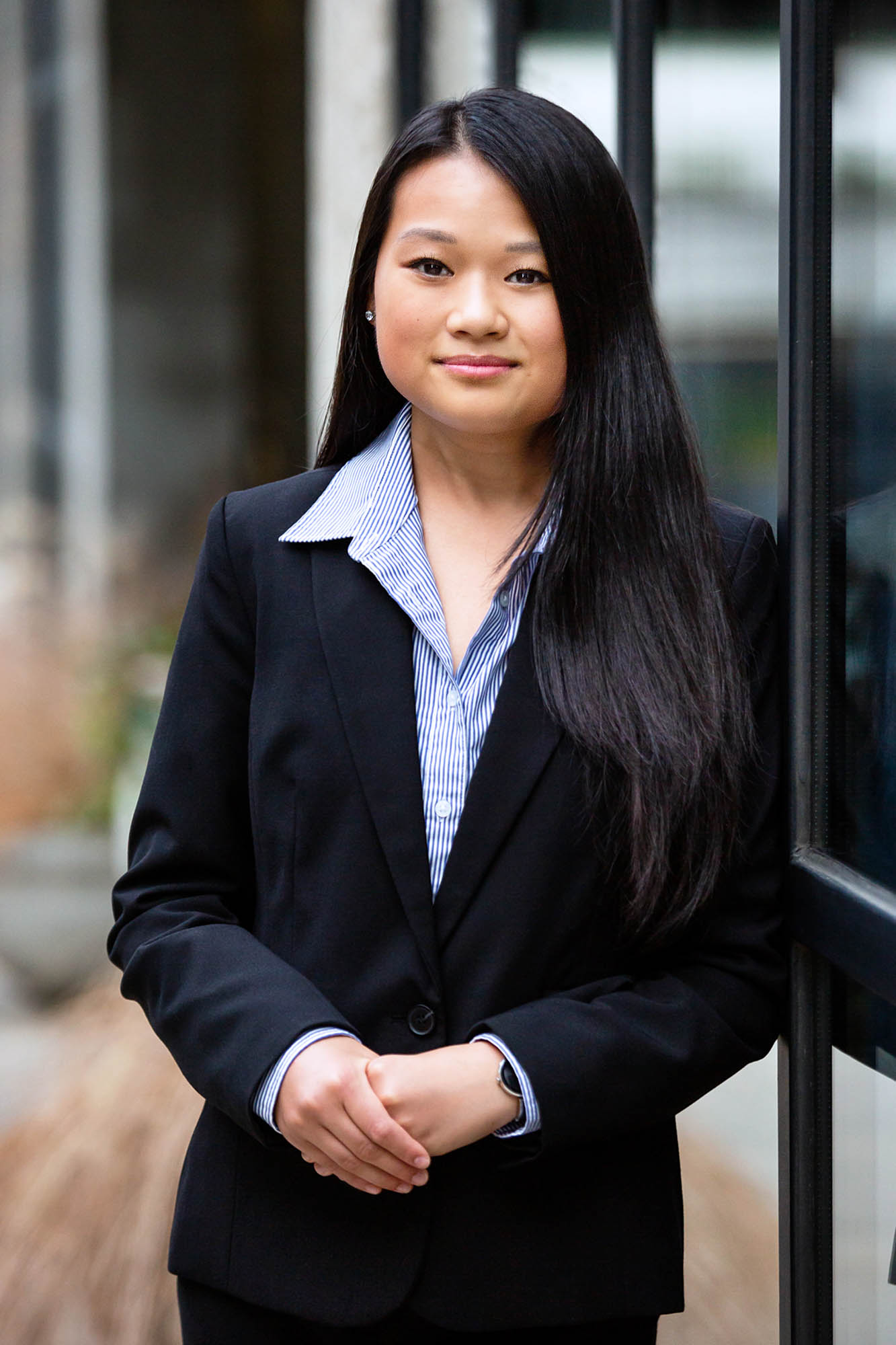 Katie wears a black pantsuit and smiles at the camera.