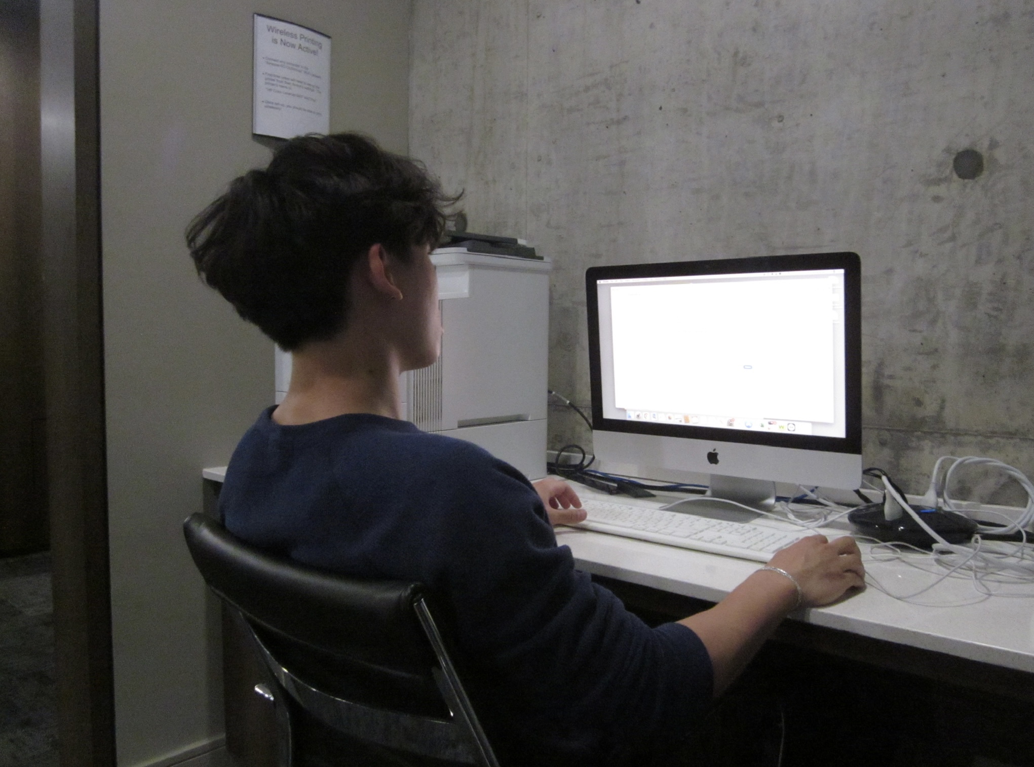 Edison works on his research on a desktop computer, with his back to the camera.