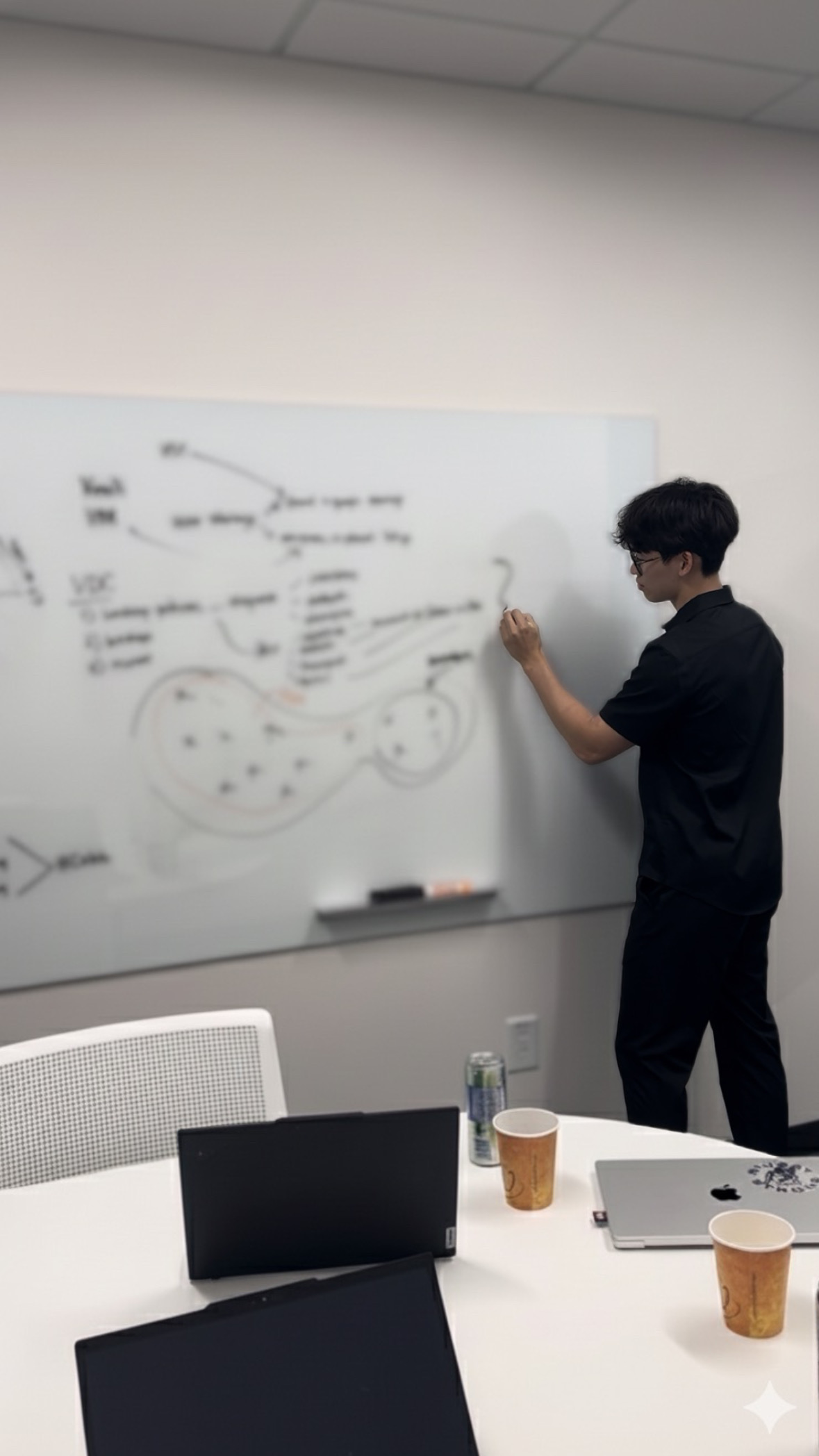 Edison writes on a white board, diagramming a problem.