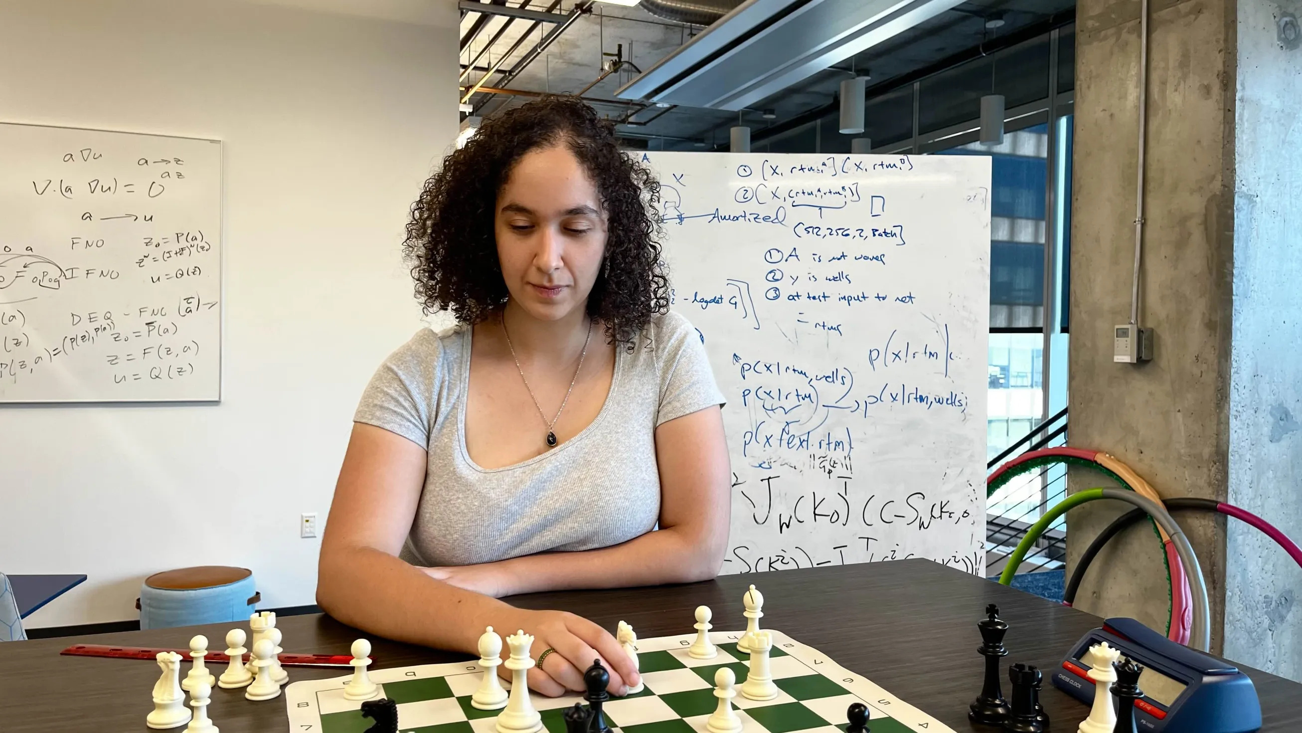 Suzan concentrates on a chess board on the table in front of her.